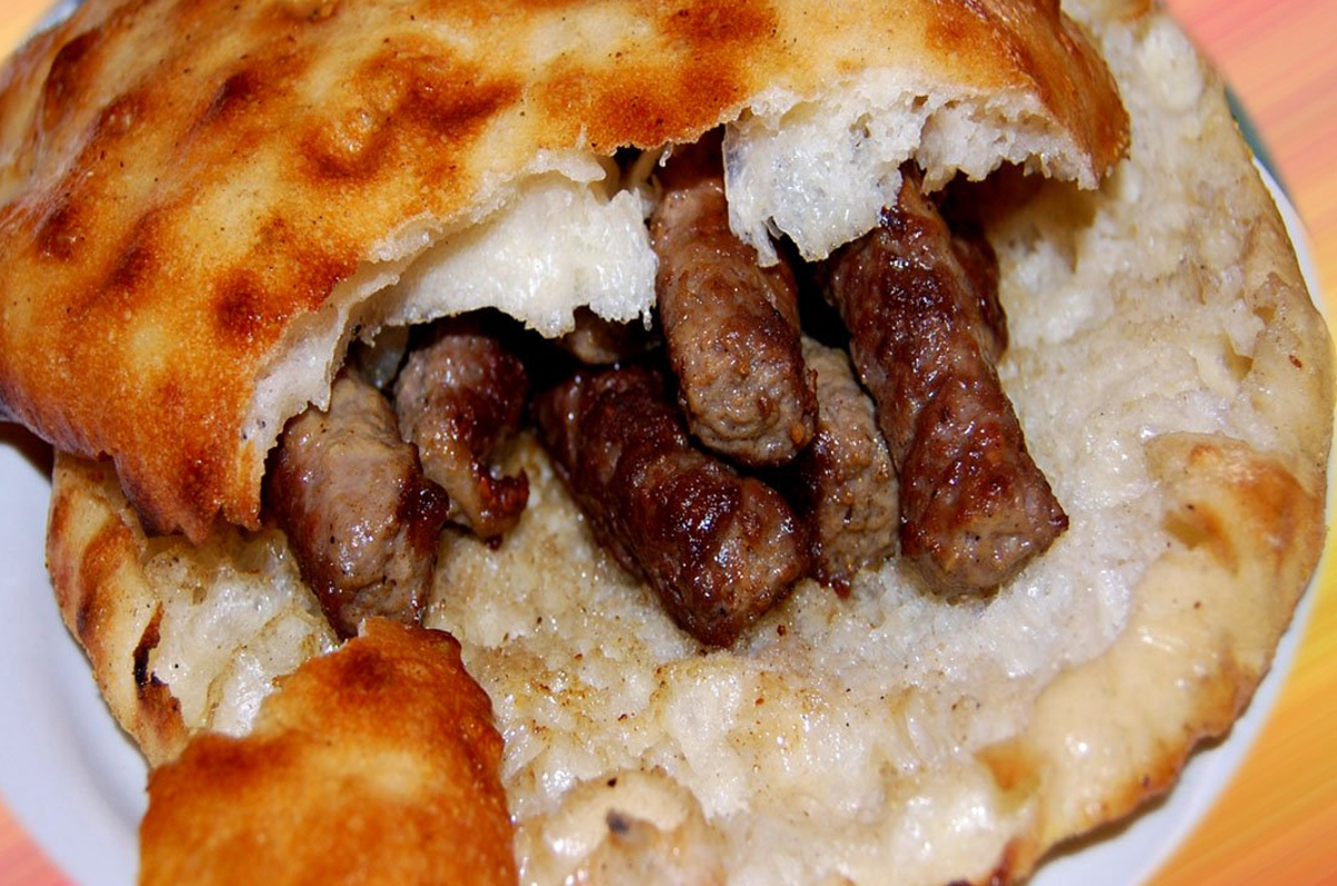 Kajmak and lepinja flatbread served with kebapi in Skopje